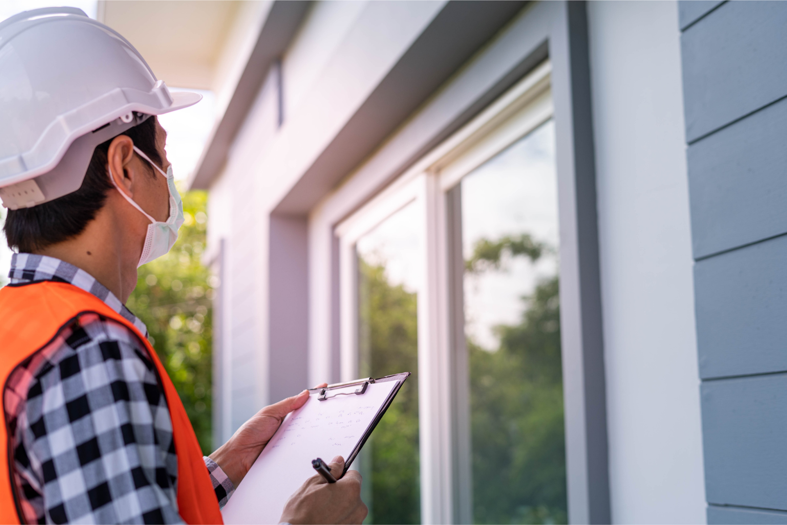 Home Inspector with clipboard observing window.