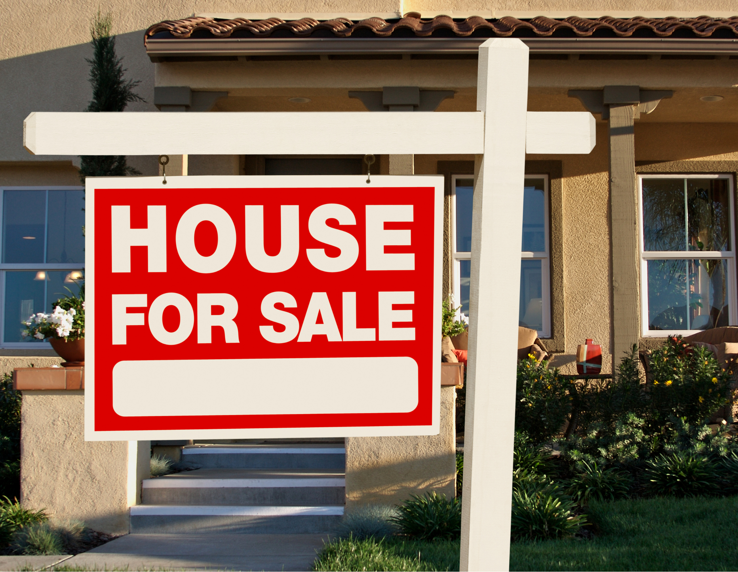 Sign in front of a house that says "House for Sale"