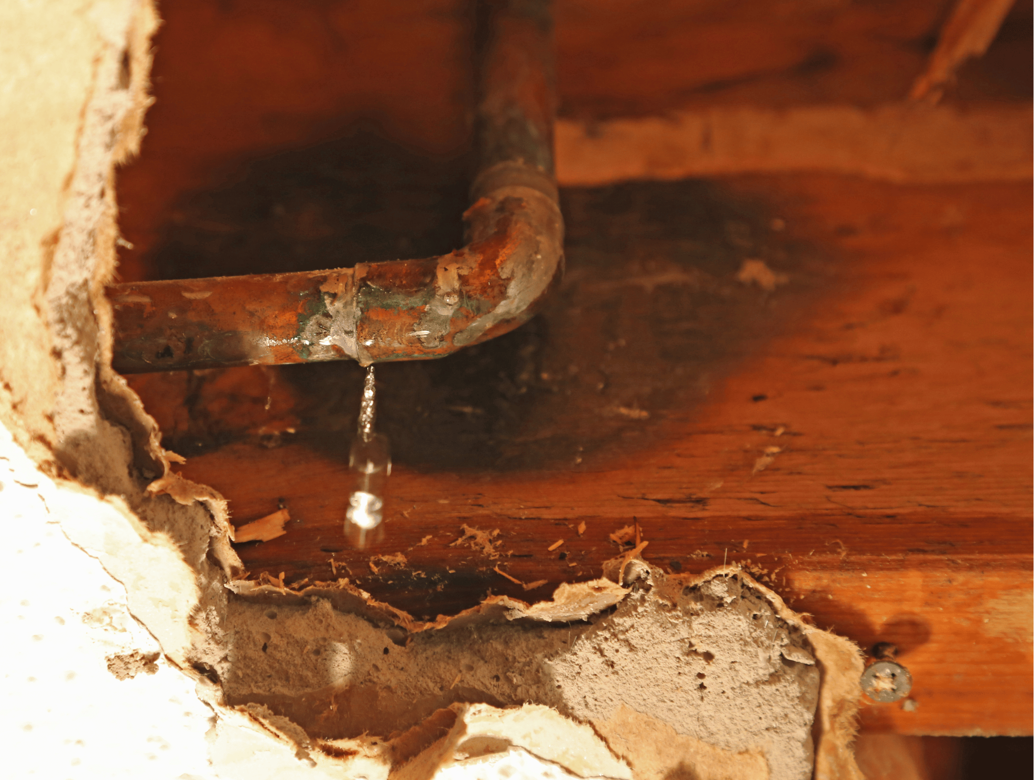 Old pipe leaking behind torn up ceiling dry wall.