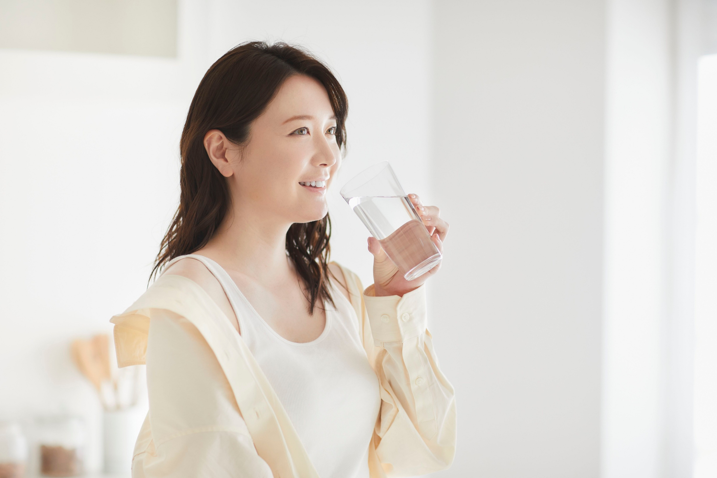 Woman about to take a drink of water from glass.