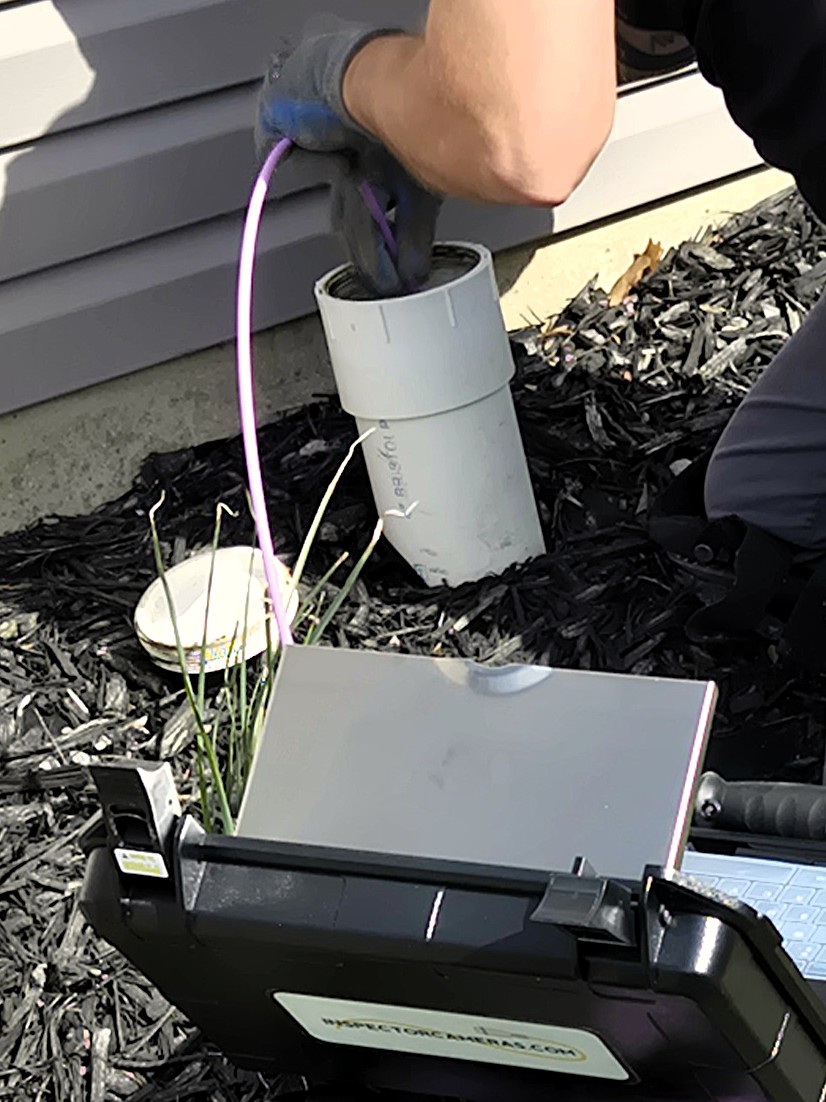 Feeding a sewer camera down the main sewer line of a customer's house.